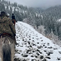 騎馬穿越白雪皚皚的山間小徑