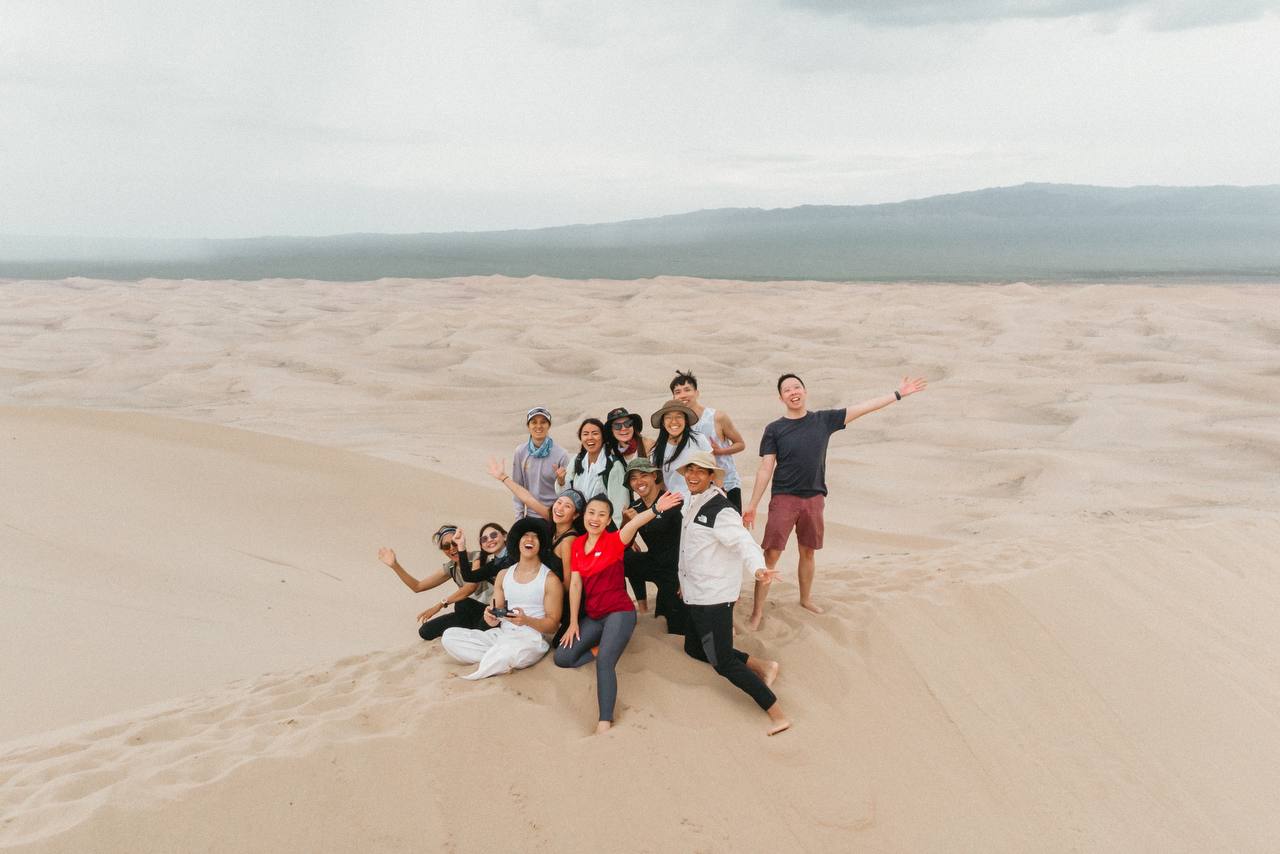 A travel group on the crest of the Gobi sand dunes, seen from a distance