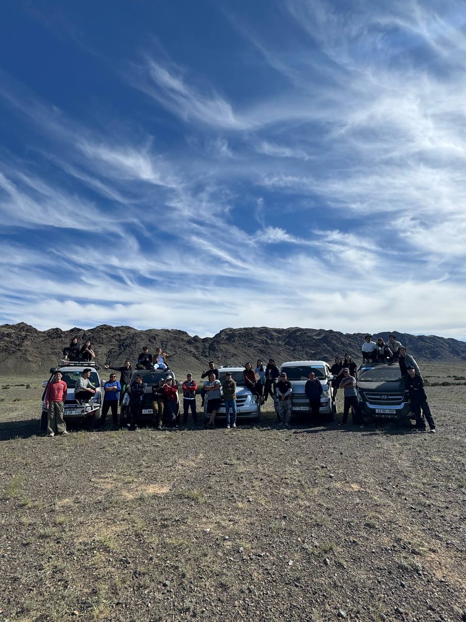 A Sotravel group with its line of 4WD jeeps on a gravel plain in the Gobi