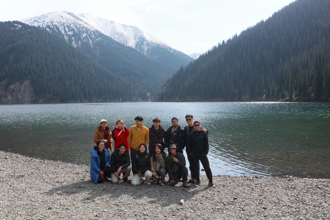 A Sotravel group on the stony shore of a mountain lake on the Kyrgyzstan & Kazakhstan trip